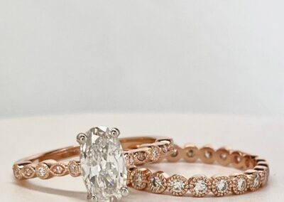 Matching engagement and wedding band in gold with embedded diamonds around each band.